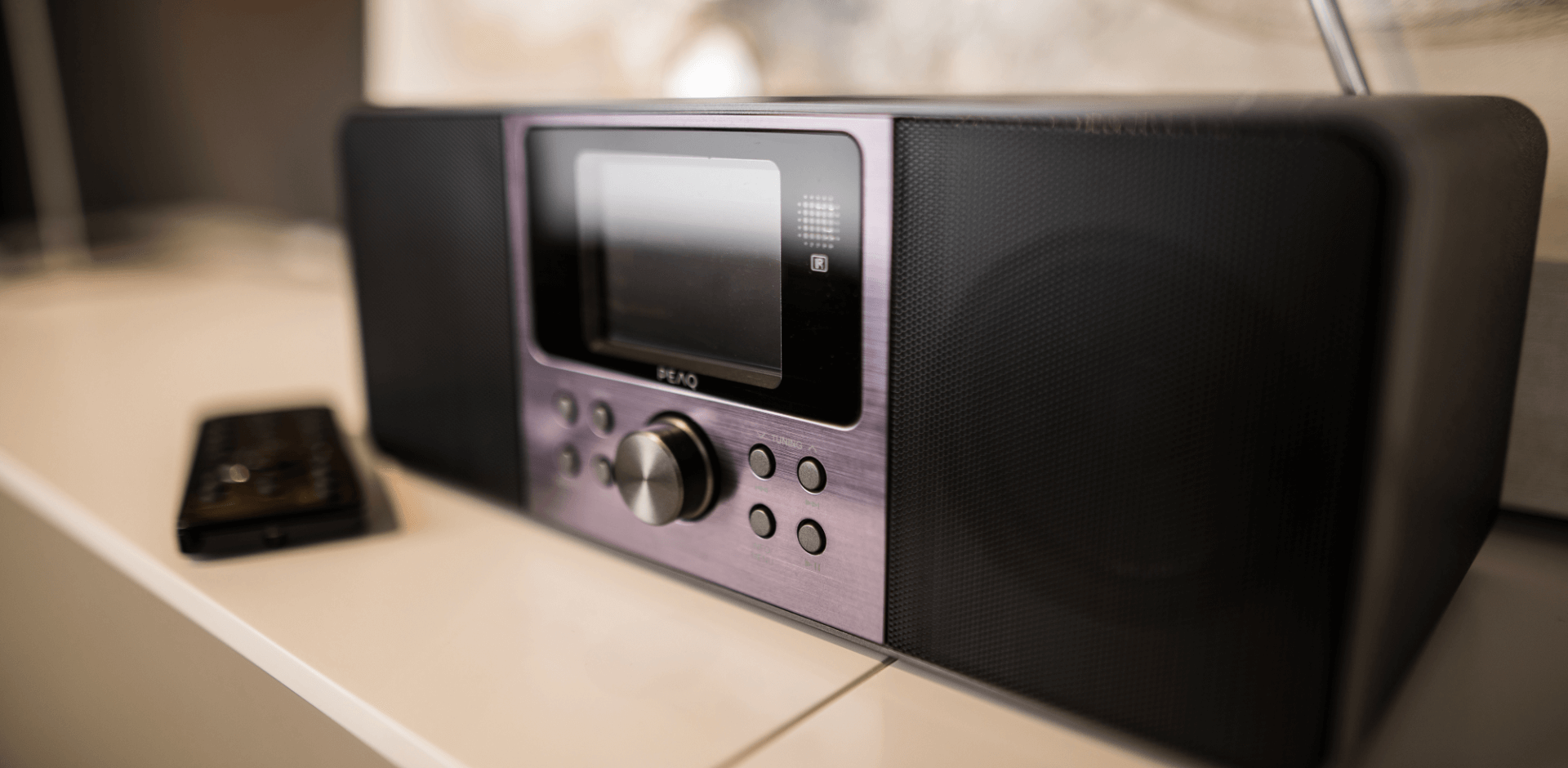 Digitalradio von PEAQ, auf weißem Sideboard, mit Fernbedienung